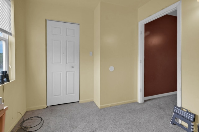 unfurnished bedroom featuring light colored carpet and a closet