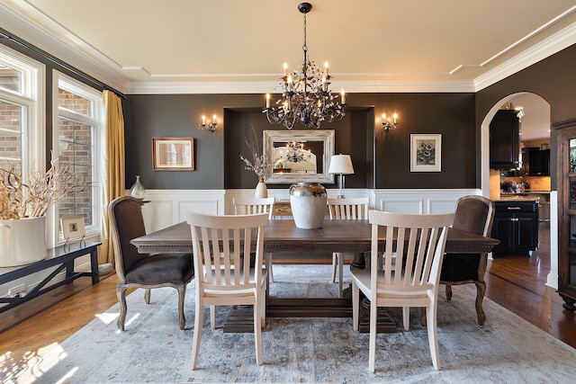 dining room featuring crown molding, hardwood / wood-style floors, and an inviting chandelier