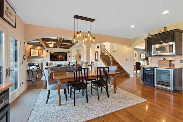 dining space featuring beam ceiling, dark wood-type flooring, beverage cooler, and coffered ceiling