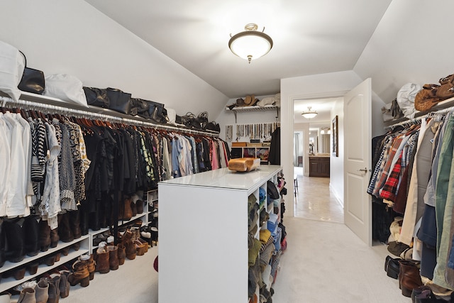 walk in closet with light carpet