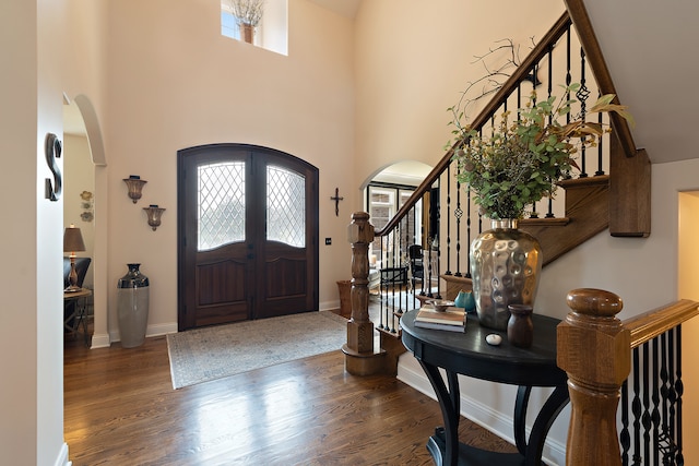 entryway with french doors, a high ceiling, and wood-type flooring