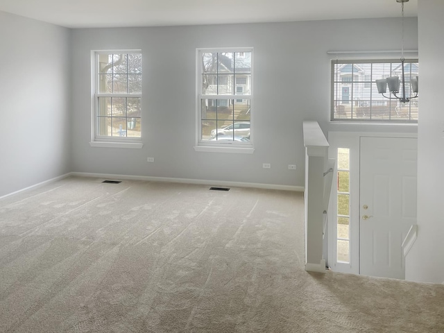 entrance foyer featuring carpet, visible vents, and a healthy amount of sunlight