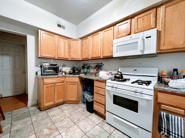 kitchen featuring white appliances and light stone countertops