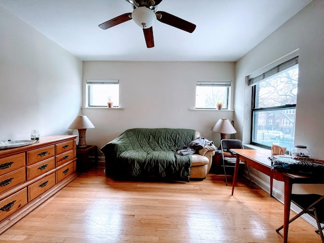 living area featuring light hardwood / wood-style floors and ceiling fan