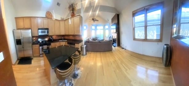 kitchen featuring appliances with stainless steel finishes, light brown cabinetry, ceiling fan, light hardwood / wood-style floors, and lofted ceiling