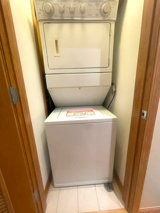 washroom with stacked washer / dryer and light tile patterned flooring