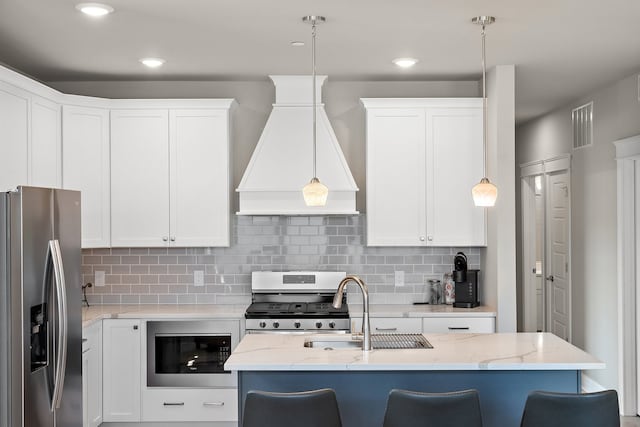 kitchen with custom exhaust hood, decorative light fixtures, light stone countertops, and stainless steel appliances