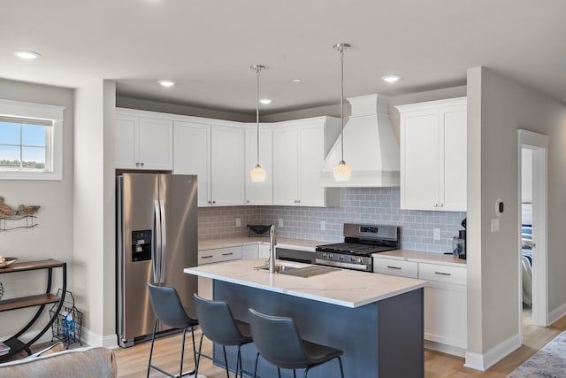 kitchen featuring light wood-type flooring, backsplash, custom range hood, light stone countertops, and stainless steel appliances