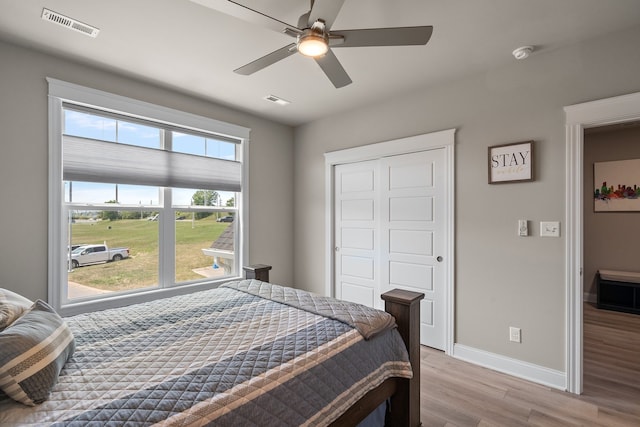 bedroom with ceiling fan, light wood-type flooring, and a closet