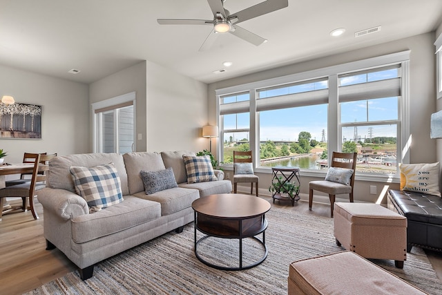 living room featuring ceiling fan and hardwood / wood-style flooring