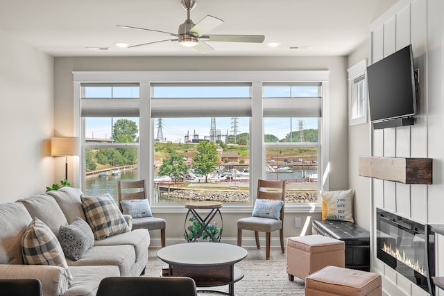 living room with a wealth of natural light, light wood-type flooring, and ceiling fan