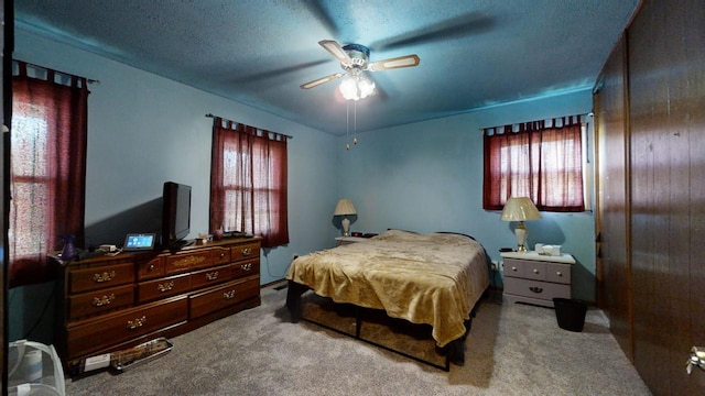 bedroom with a textured ceiling, ceiling fan, and carpet flooring