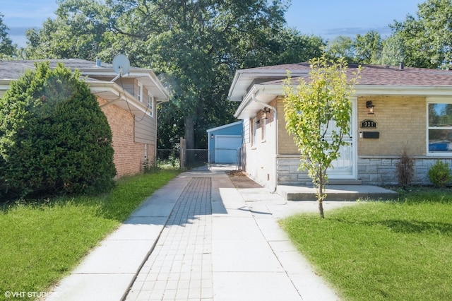 exterior space with a garage, an outbuilding, and a front yard