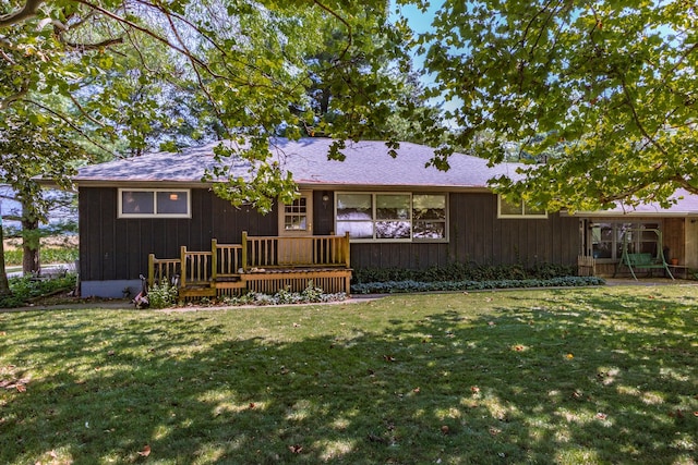 back of property with a lawn and a deck