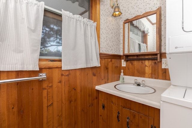 bathroom with vanity, toilet, and wooden walls