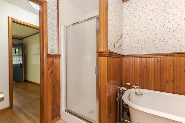 bathroom with hardwood / wood-style floors, independent shower and bath, wooden walls, and ornamental molding