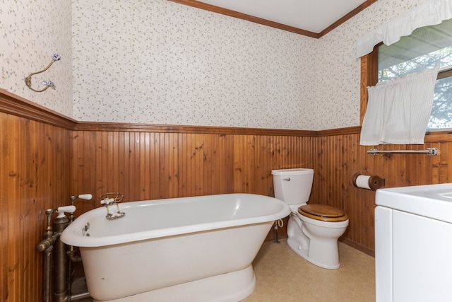 bathroom with vanity, toilet, a tub, and wooden walls