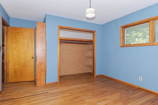 unfurnished bedroom with light hardwood / wood-style flooring and a closet