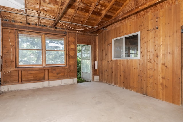 miscellaneous room featuring lofted ceiling, a healthy amount of sunlight, and concrete flooring