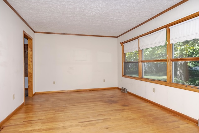 spare room featuring crown molding, a textured ceiling, and light hardwood / wood-style flooring