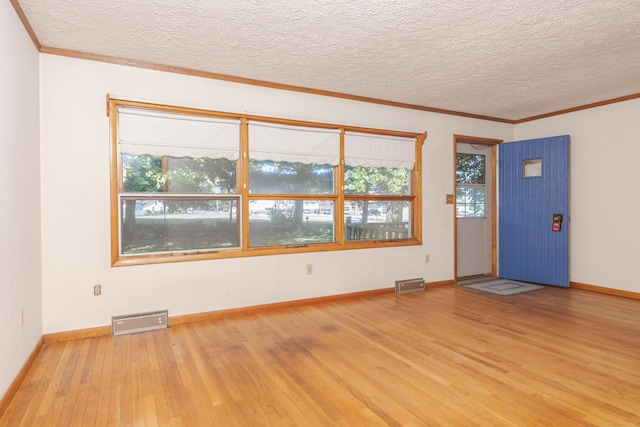 foyer with ornamental molding, a textured ceiling, and hardwood / wood-style flooring