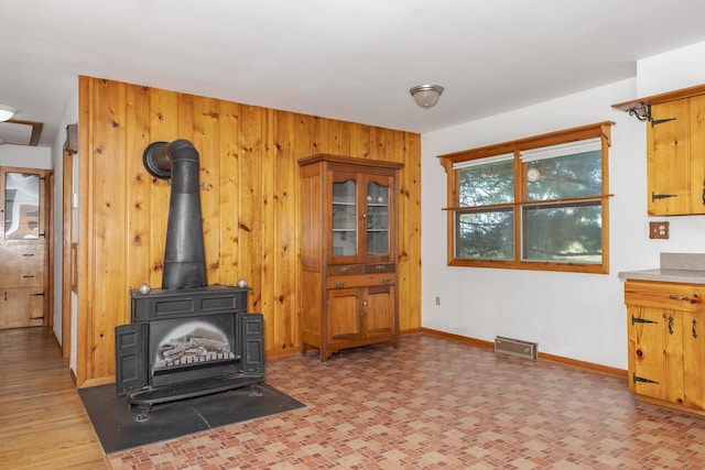 living room with a wood stove, wood walls, and hardwood / wood-style flooring