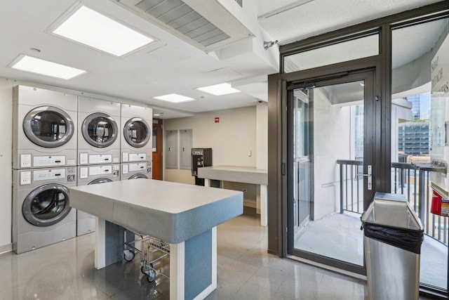 community laundry room featuring stacked washer / dryer