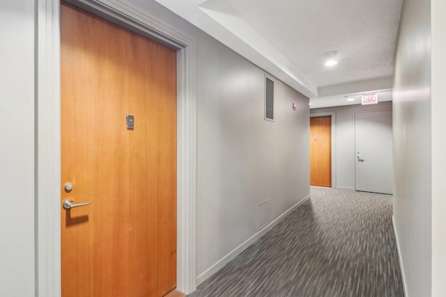 hall with baseboards, carpet floors, and visible vents