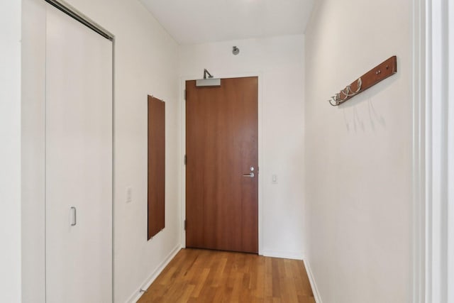 hall with baseboards and light wood-style floors