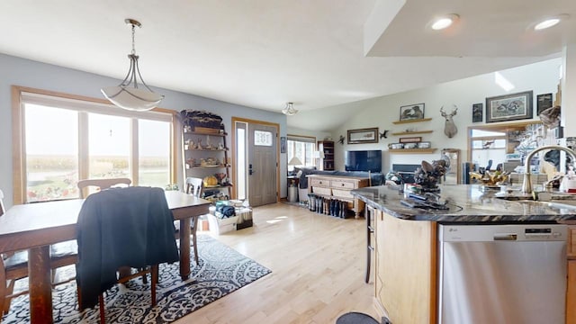 kitchen with vaulted ceiling, light hardwood / wood-style flooring, dishwasher, pendant lighting, and sink