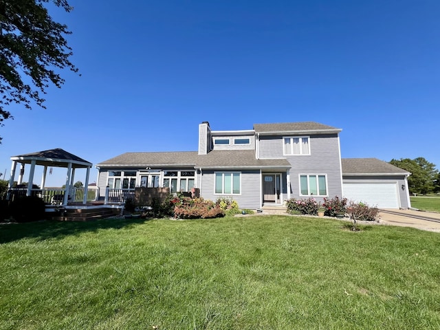 rear view of house with a yard and a garage