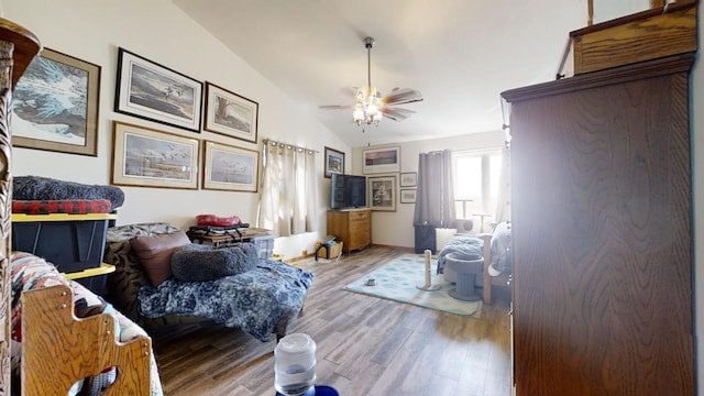 bedroom with light hardwood / wood-style floors, vaulted ceiling, and ceiling fan