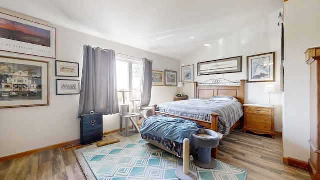 bedroom featuring vaulted ceiling and hardwood / wood-style flooring