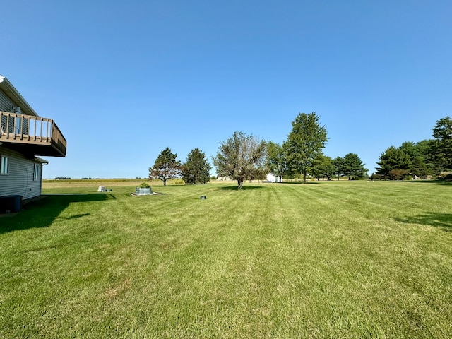 view of yard featuring a balcony and central AC