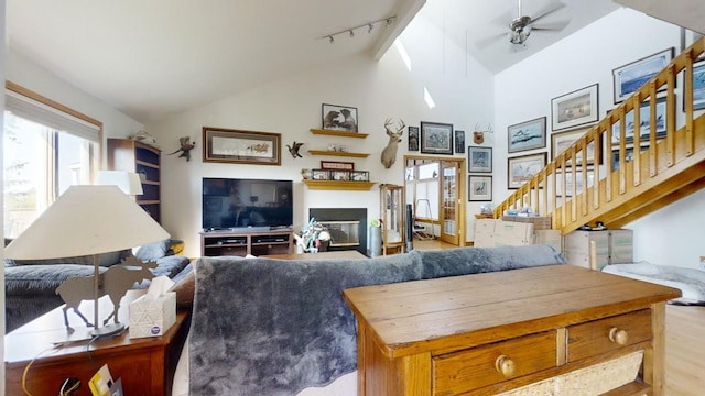 living room featuring track lighting, high vaulted ceiling, light hardwood / wood-style floors, and ceiling fan