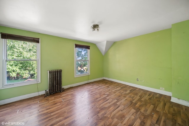 spare room featuring radiator and hardwood / wood-style floors