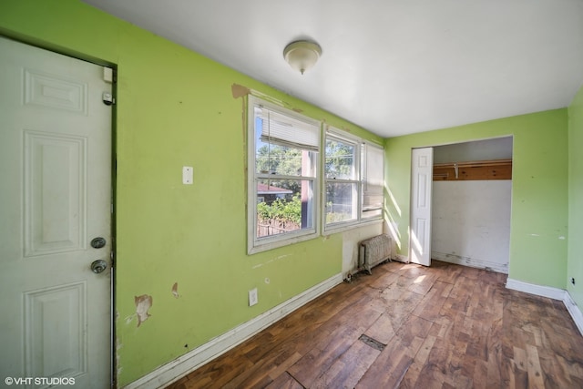 interior space featuring a closet, radiator, and dark hardwood / wood-style floors