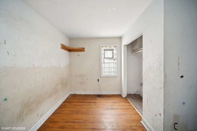 unfurnished bedroom with a closet and hardwood / wood-style flooring