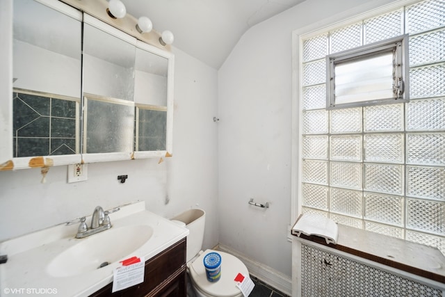 bathroom featuring toilet, vanity, and lofted ceiling