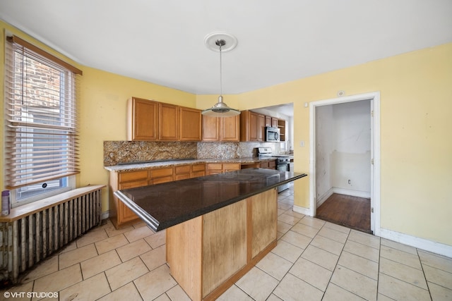 kitchen featuring tasteful backsplash, a kitchen island, appliances with stainless steel finishes, and light tile patterned floors