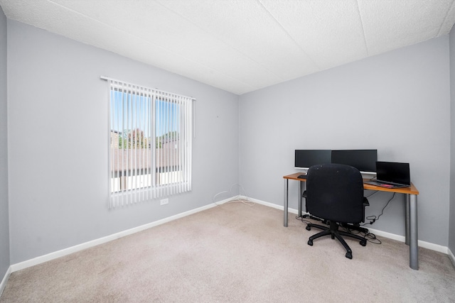 carpeted office featuring a textured ceiling