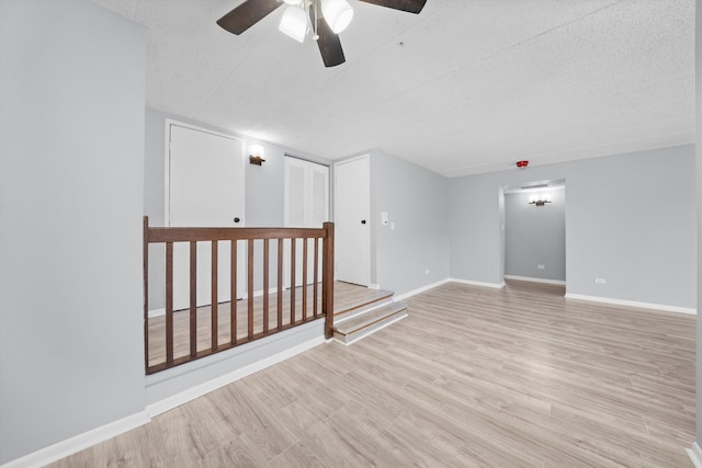 empty room featuring light hardwood / wood-style flooring, a textured ceiling, and ceiling fan