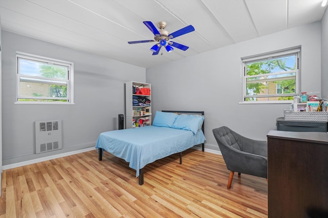 bedroom with light wood-type flooring, ceiling fan, and multiple windows