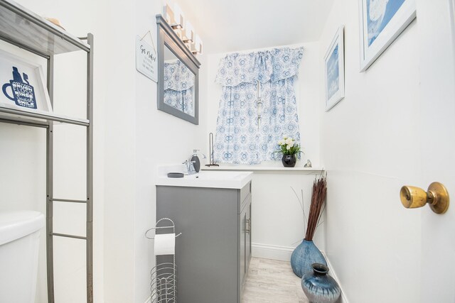 bathroom with vanity, hardwood / wood-style floors, and toilet