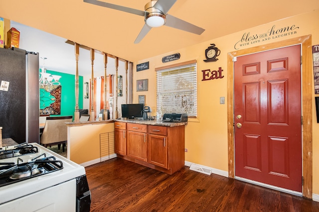 kitchen featuring stainless steel refrigerator, ceiling fan, white gas stove, and dark hardwood / wood-style floors