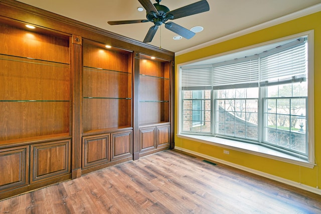 interior space with ornamental molding, plenty of natural light, light hardwood / wood-style floors, and ceiling fan