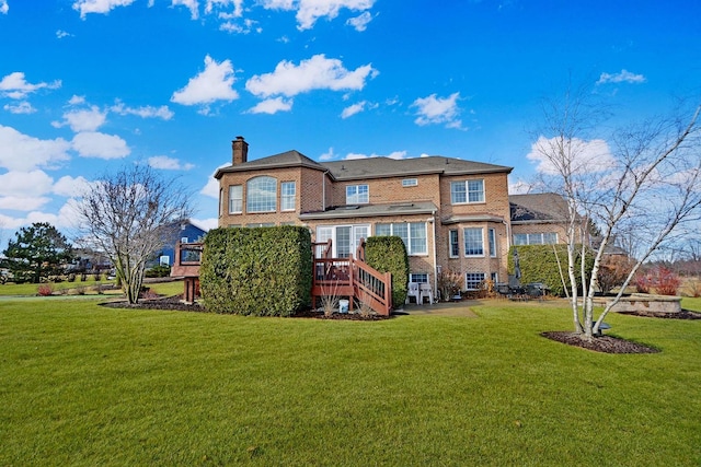 back of property with a wooden deck and a yard