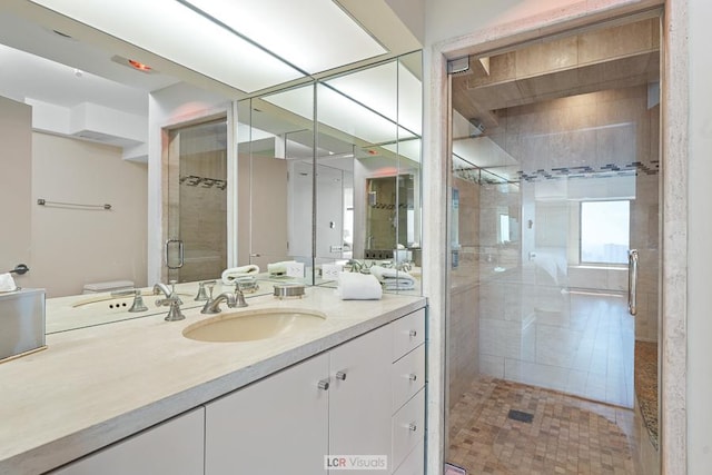 bathroom with toilet, a stall shower, and vanity