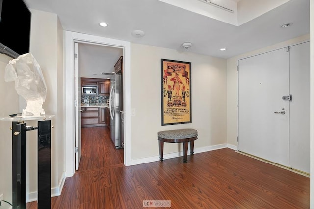 corridor featuring recessed lighting, baseboards, and dark wood finished floors