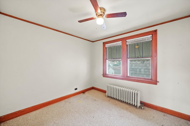 spare room featuring ornamental molding, radiator, ceiling fan, and carpet